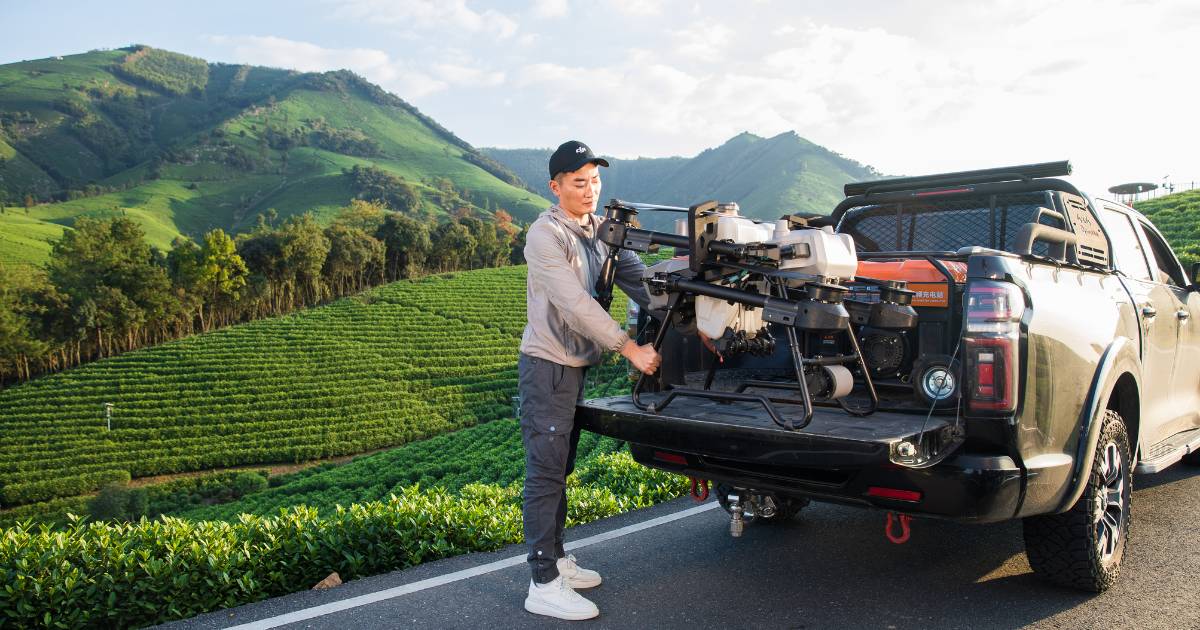 Homem retirando Drone Agrícola DJI Agras T25 da carroceria de uma caminhote.