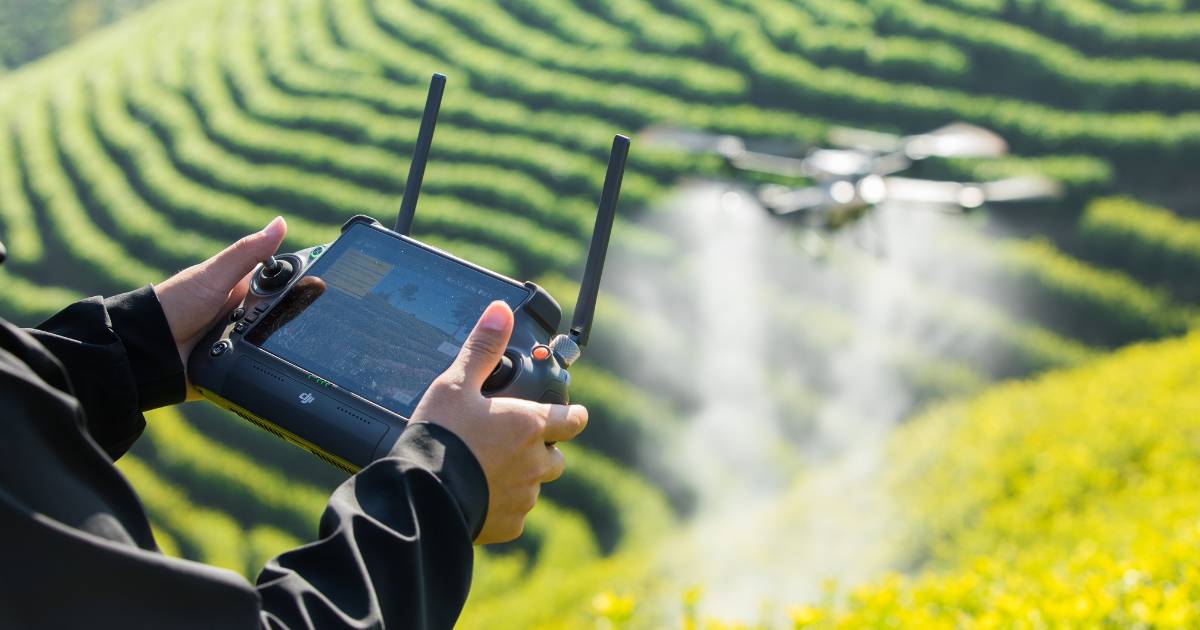 Homen com controle de Drone Agrícola DJI T50 realizando pulverização.