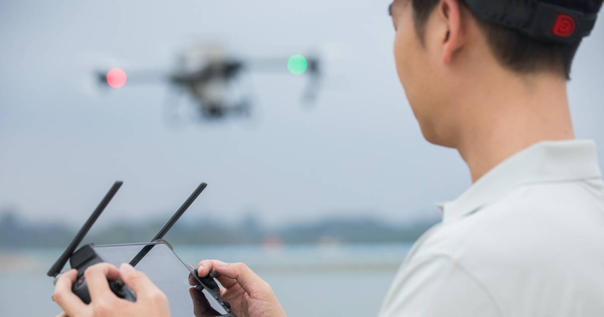 Piloto de drone agrícola DJI T50 com controle na mão.